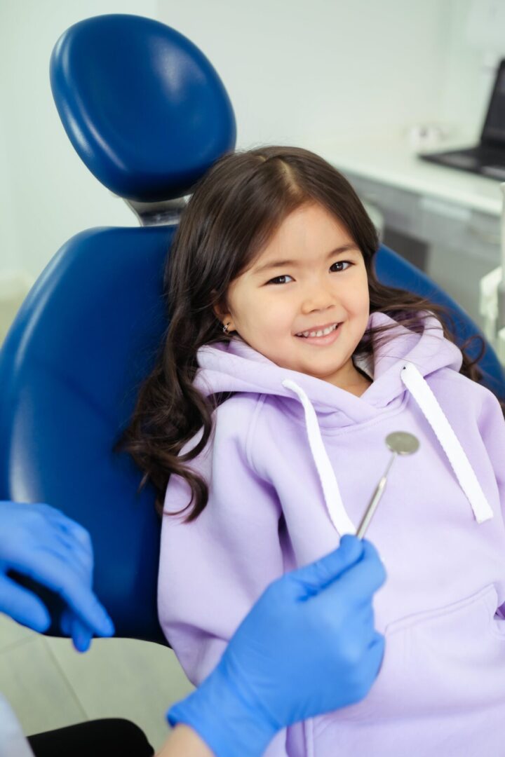 A little girl sitting in the dentist chair